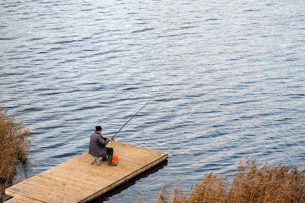 木製の橋で釣り竿を持つ漁師