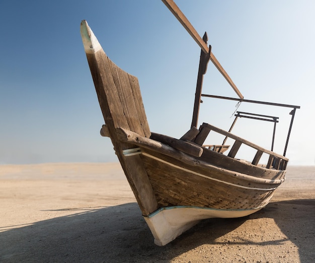 照片的渔夫的船或单桅三角帆船在沙地上
