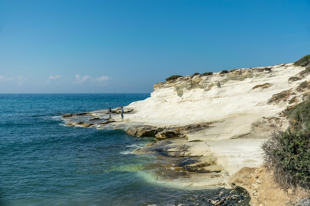 I pescatori pescano in riva al mare costa di pietre bianche