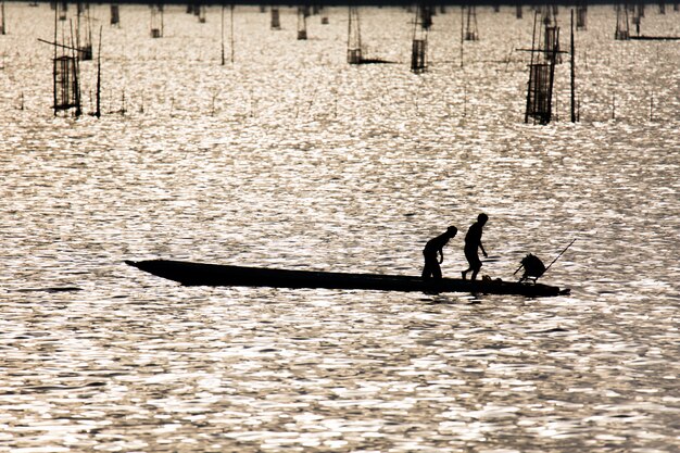 Рыбаки используют рыболовные инструменты утром вдоль озера Сонгкхла.