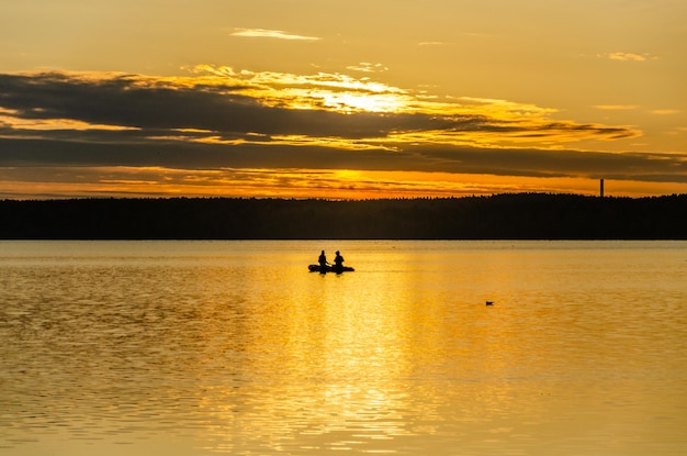 Fishermen in a boat on the lake at dawn.