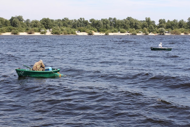 Fishermen on boats catch fish in the river