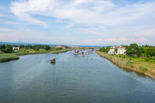 Рыбаки ловят рыбу в хижинах, построенных на воде.