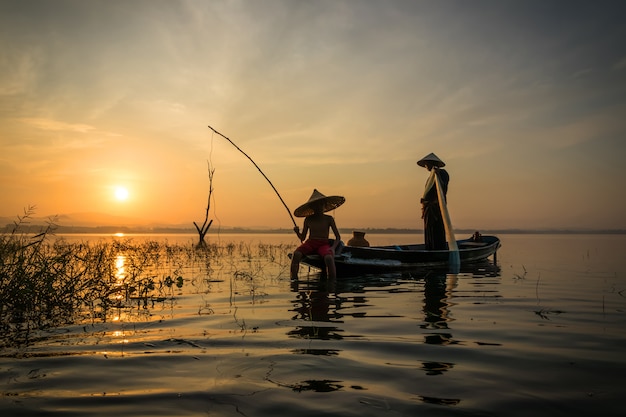 Fishermen Fishing rod with hook are going out to fish early in the morning with wooden boa