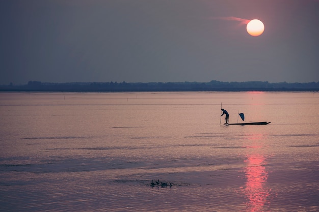 Photo fishermen make a living by using traps to catch fish that have nets like catching fish during the sunset.