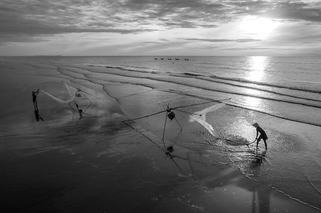 Foto pescatori che lavorano con le reti sulla spiaggia