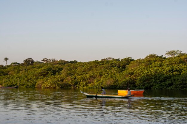 Fisherwoman rowing the canoe towards the jaguaripe river\
pier