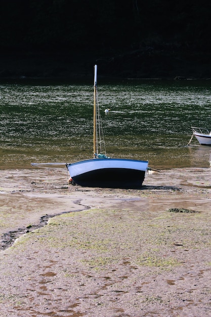 干潮時に川の砂浜に停泊する漁船