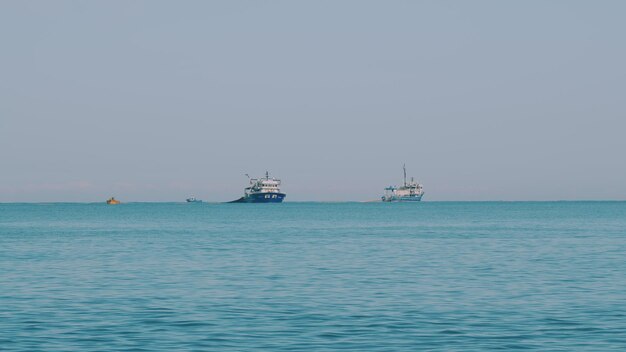 海の地平線にある漁船 静かな水面上の抽象的な小さな波が動いています