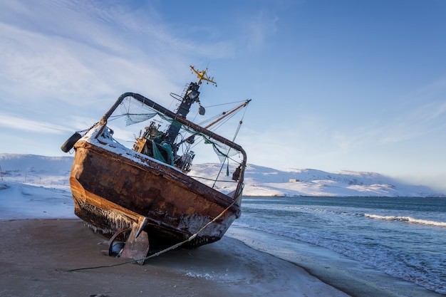 A fishing boat lying on its side, the Barents sea, the Kola Peninsula, Teriberka, Russia