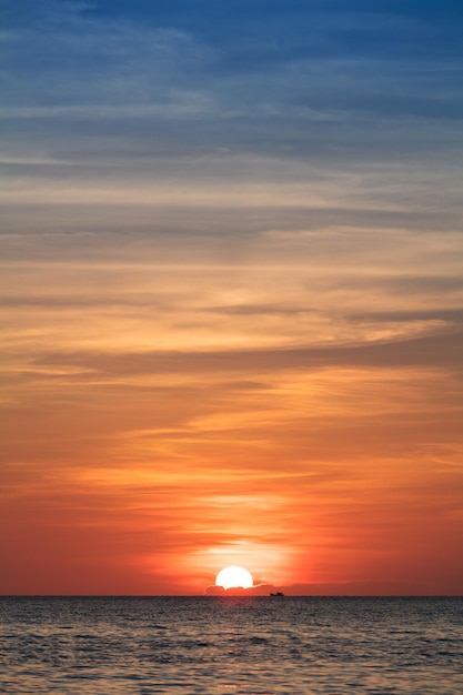 Fishing boat in ocean at sunset