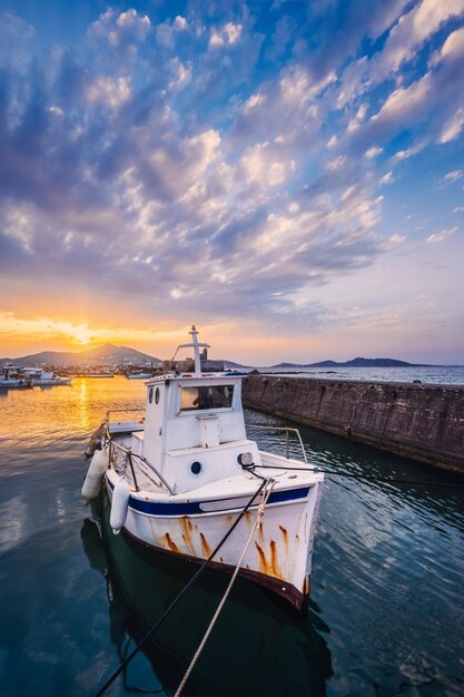 Foto barca da pesca nel porto di naousa al tramonto isola di paros grecia