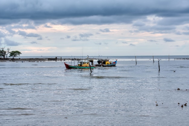 fishing boat sailing in the distance of the sea