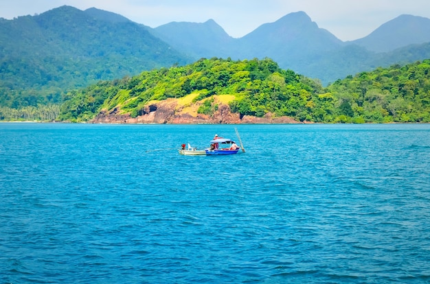 A fishing boat with fishermen in the open sea. Sea fish. National craft.