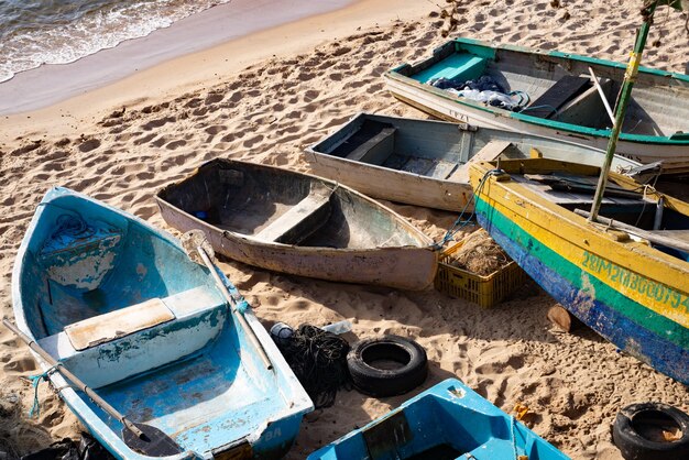 Photo fishing boats are seen on the sand of rio vermelho beach in the city of salvador bahia