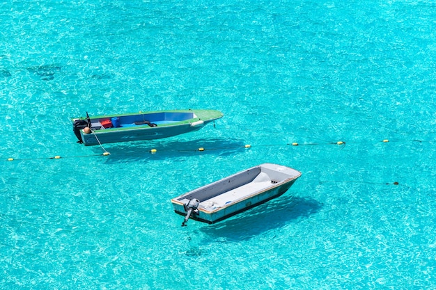 Fishing boats floating above the sea on a sunny day.