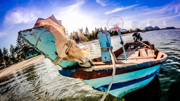 Photo fishing boats moored in sea against sky