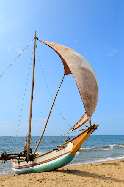 Photo fishing boats resting on empty beach in sri lanka