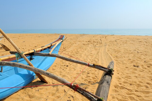 Photo fishing boats resting on empty beach in sri lanka