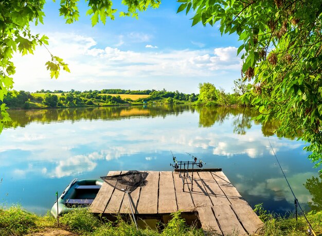 Fishing equipment on wooden pier and calm river in the morning