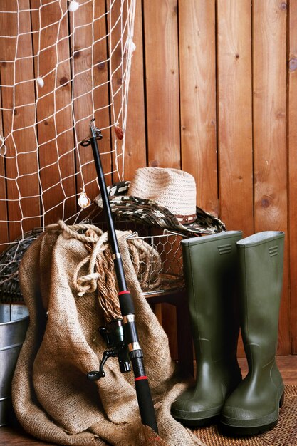 Fishing equipment on wooden wall background indoors