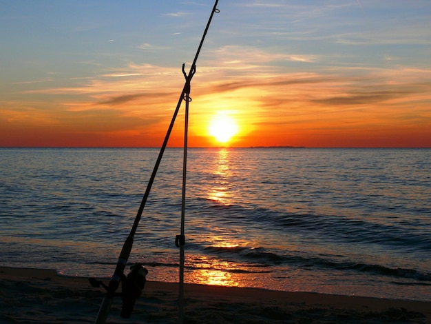 Fishing from the sandy beach spinning rods and fishing rods stand on the shore