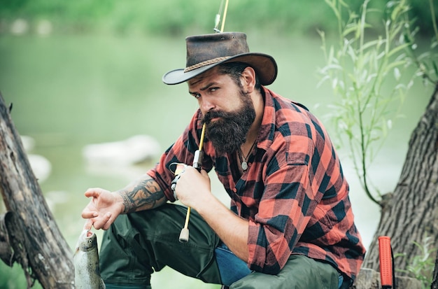 fishing hobby and summer weekend bearded men fisher with fishing rod