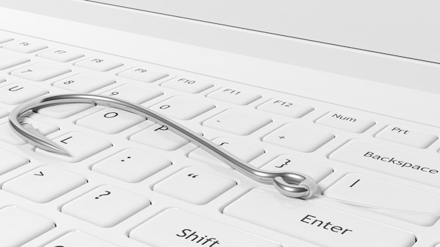 Fishing hook on white laptop keyboard