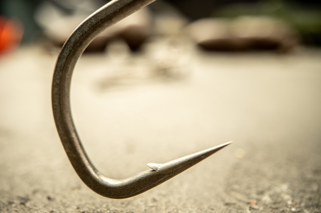 Fishing hooks on concrete textured background macro shot