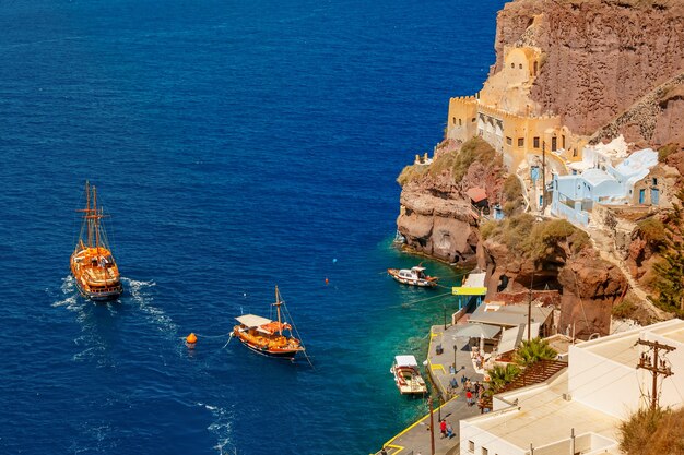 ギリシャの晴れた日、ギリシャのエーゲ海の島、サントリーニ島の近代的な首都、フィラの旧港、メサジャロスでの釣りとモーターボート