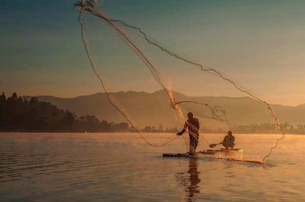 Photo fishing net on lake against sky during sunset