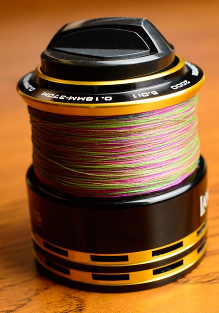 Fishing reel spool with colorful fishing line - macro photo.
