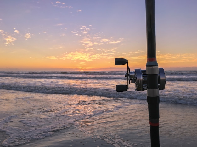 Canna da pesca sulla spiaggia al tramonto surf cast