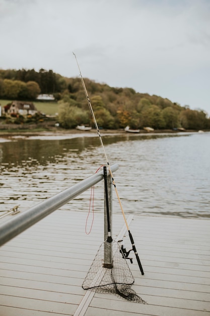 Canna da pesca e rete su un molo del lago