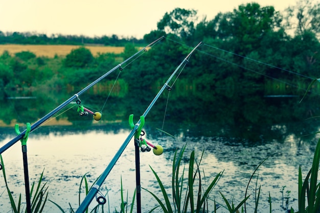 Fishing rod on the river bank. catching fish at sunrise