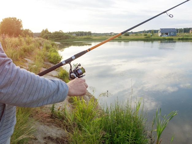 Fishing rod wheel closeup man fishing on the lake