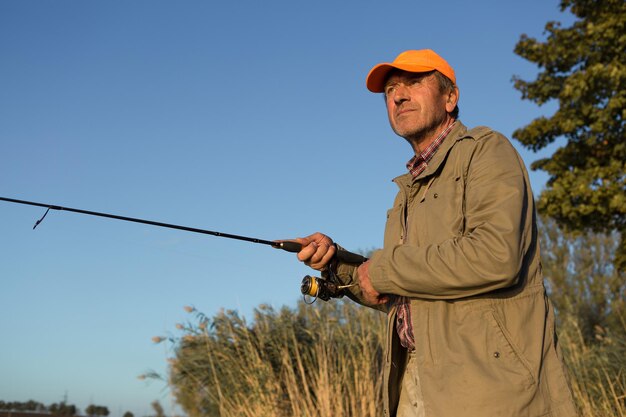 Fishing rod wheel closeup man fishing with a beautiful sunset