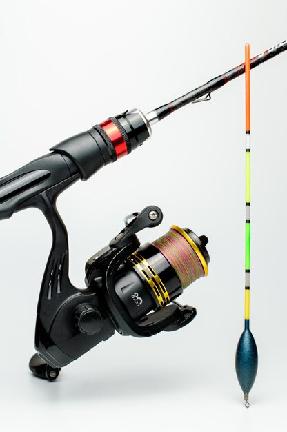 Premium Photo  Fishing rod with a reel and float on a white background.