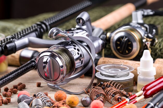 Fishing rods and spinnings in the composition with accessories for fishing on the old surface on the table