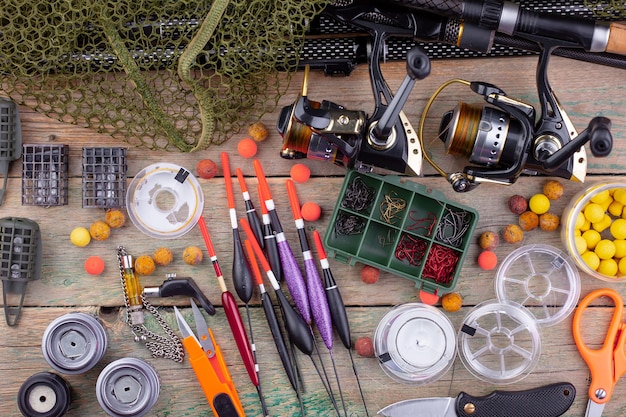 Fishing rods and spinnings in the composition with accessories for fishing on the old surface on the table