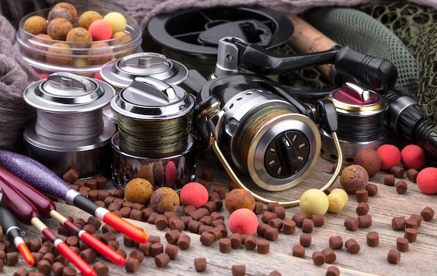 Fishing rods and spinnings in the composition with accessories for fishing on the old surface on the table