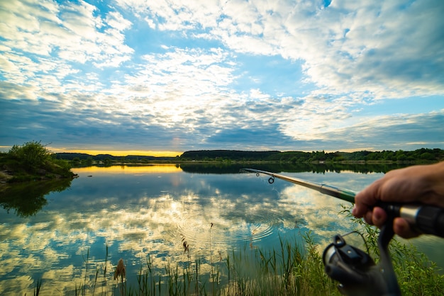 Fishing on summer sunset lake