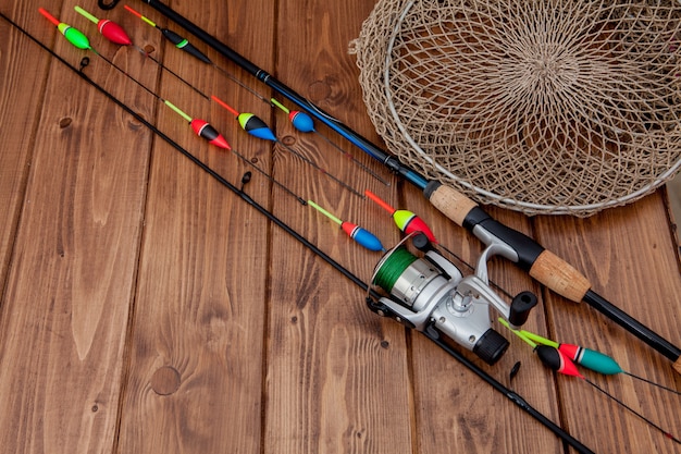 Fishing tackle - fishing rod fishing float and lures on beautiful blue wooden background, copy space