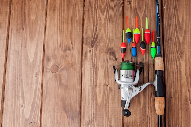 Fishing tackle - fishing rod fishing float and lures on beautiful blue wooden background, copy space.