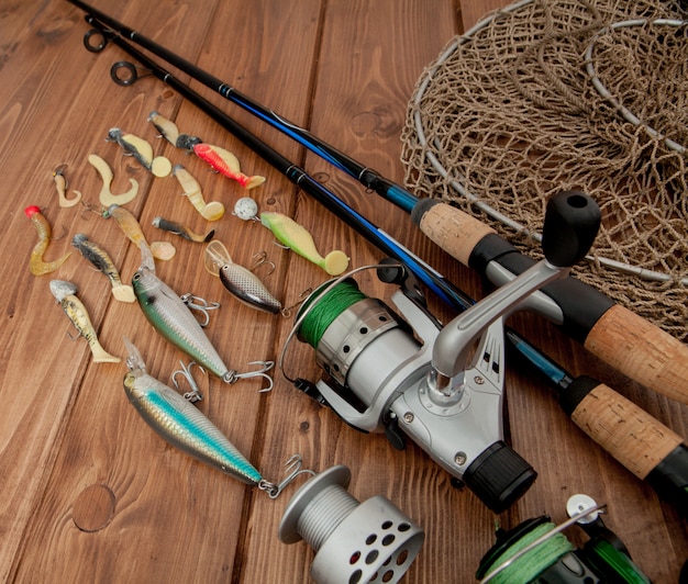 Fishing tackle - fishing spinning, hooks and lures on wooden background with copy space