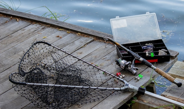 川岸での釣り道具、ベイトロッド、スピニングロッド、魚。自然。セレクティブフォーカス