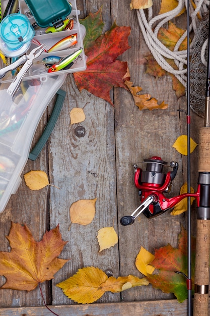 Fishing tackles on board with leafs of autumn