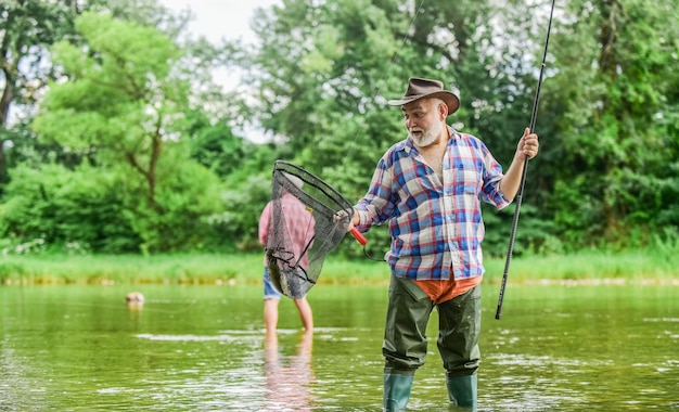 fishing therapy grandfather fishing male friendship family bonding summer weekend fishermen with fishing rods selective focus retired mature man fisher hobby and sport activity