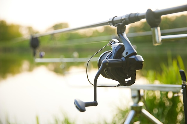 Photo fishings reel closeup on the background of the river fishing reel fishing rod with aluminum body spool fishing gear fish supplies and equipment