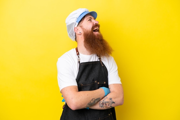 Fishmonger wearing an apron isolated on yellow background happy and smiling